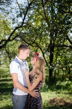 Genç çift sonbahar meyve bahçesinde sarılma