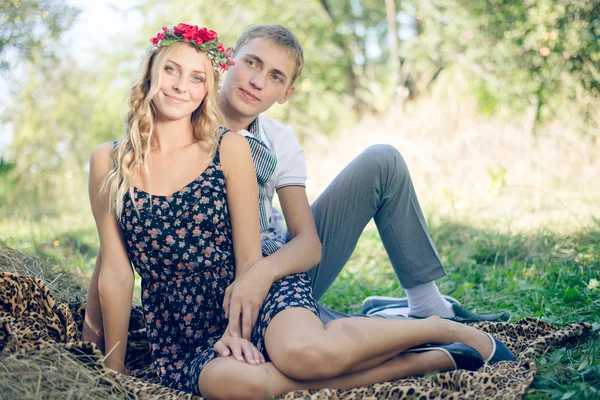 Couple hugging on haystack on green outdoors — Stock Photo, Image