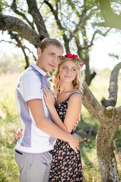 在秋天的果园中拥抱对年轻的夫妇 — 图库照片