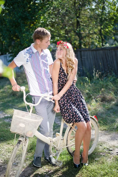 Young couple sitting on bicycle and looking at each other — Stock Photo, Image