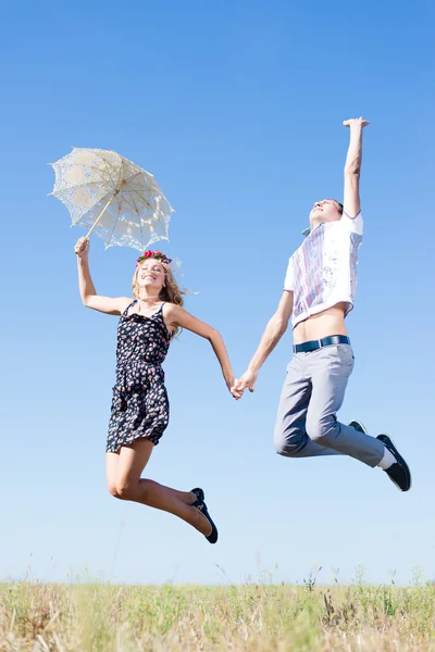 Couple holding hands and jumping high at blue sky Royalty Free Stock Photos