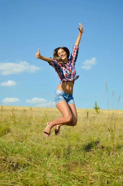 Jumping alegria: sexy menina bonita em calções de ganga correndo alto e feliz sorrindo no céu azul ao ar livre copiar fundo espaço, retrato — Fotografia de Stock