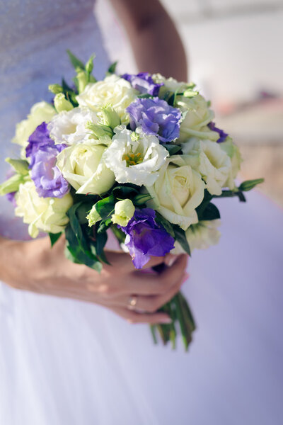 Wedding roses bouquet in bride hands closeup