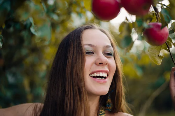 Closeup portrait of young sexy pretty woman laughing joyfully at apple tree on green outdoors copy space background — Stock Photo, Image