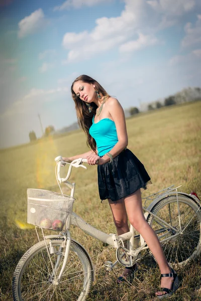 Bella avventura in bicicletta: sexy giovane bella signora divertirsi con la bicicletta nei campi sotto il cielo blu brillante estate su sfondo spazio copia verde, ritratto — Foto Stock