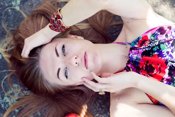 Close up imagem de bela jovem loira sensual menina bonita com olhos azuis deitado com maçãs em pedra pedra ou gelo chão & olhando para longe no retrato espaço cópia — Fotografia de Stock