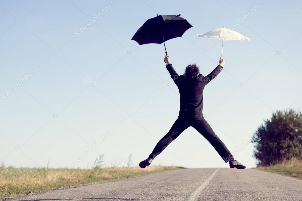 Businessman with umbrella flying