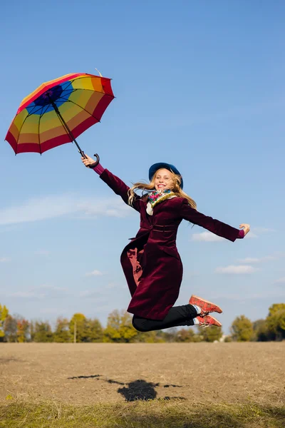 Donna con ombrello saltando — Foto Stock