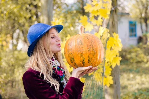 Portret gospodarstwa dyni elegancki piękna blond hipster młode kobiety zabawy szczęśliwy uśmiechający się i patrząc na kamery na jesieni kopiować miejsca na zewnątrz tło — Zdjęcie stockowe