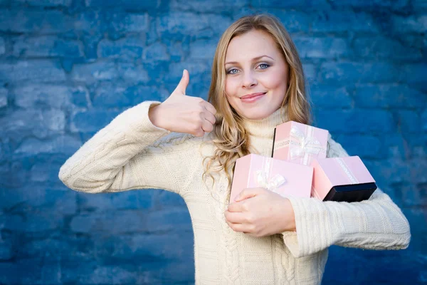 Vonzó szőke fiatal nő gyapjú pulóver kapott ajándékokat, boldog, mosolyog a kék téglafal háttér szórakozás — Stock Fotó