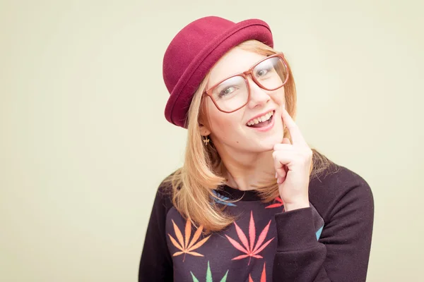 Studio portrait of teenage hipster girl wearing trendy eyeglasses and hat over olive copy space background — Stock Photo, Image