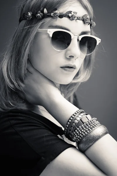 Estudio retrato en blanco y negro de adolescente hipster o chica hippie con flores de moda corona y gafas de sol sobre el espacio de copia de fondo — Foto de Stock