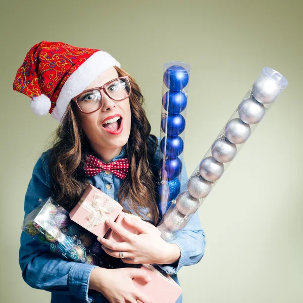 Fille en chapeau de Noël tenant des boules et des cadeaux de Noël — Photo