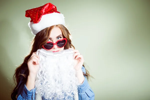 Girl in Christmas hat and beard santa and sunglasses — Stock Photo, Image