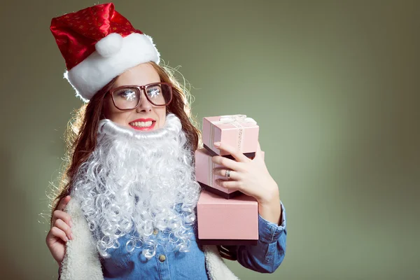 Girl in Christmas hat, glasses and beard santa holding a christmas balls and gifts — Stock Photo, Image