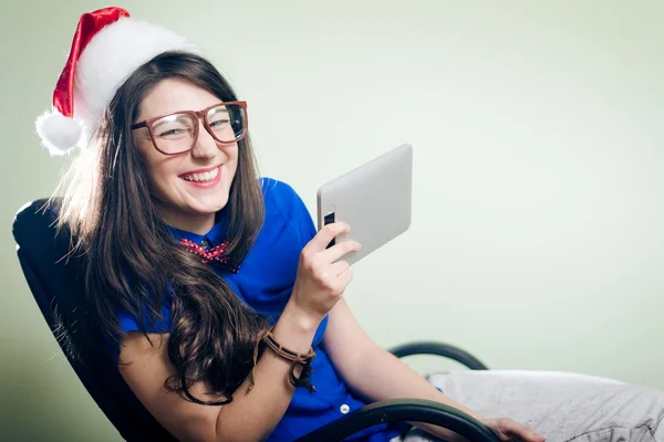 Girl in Christmas hat holding tablet — Stock Photo, Image