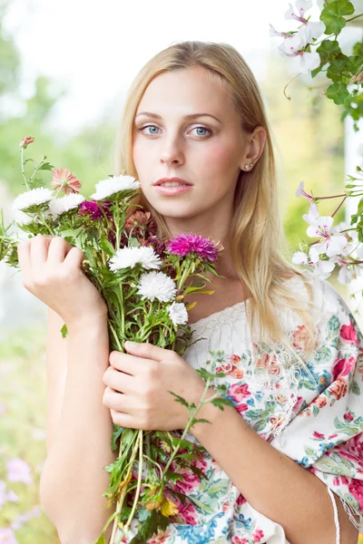 Flicka med blommor i händerna — Stockfoto