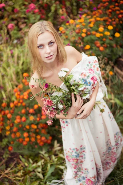 Meisje met bloemen in handen — Stockfoto