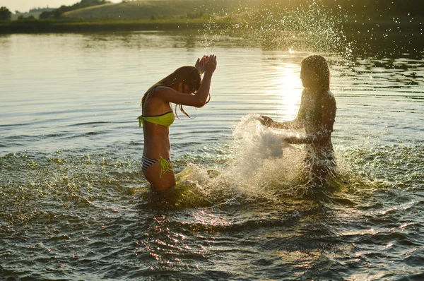 Девушки в озере на закате — стоковое фото