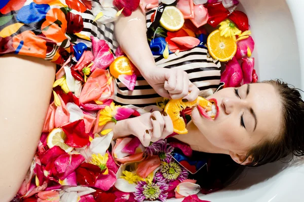 Mujer en baño con pétalo de flores . — Foto de Stock