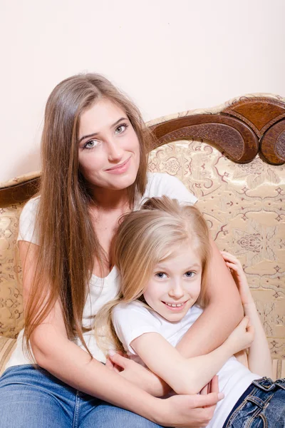 Woman and girl on sofa — Stock Photo, Image