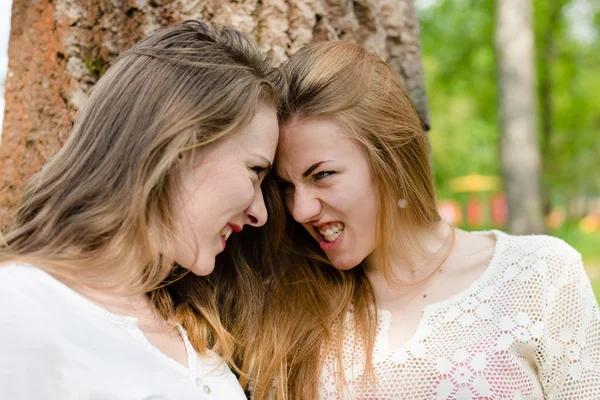 Twee meisjes onder boom — Stockfoto