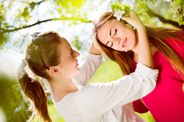 Twee meisjes onder boom — Stockfoto