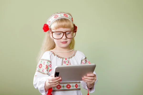 Little girl in Ukrainian clothes with tablet — Stock Photo, Image