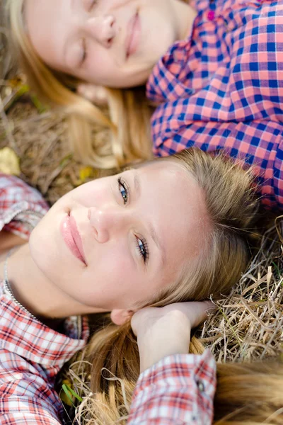Glada tjejer liggande huvud till huvud — Stockfoto