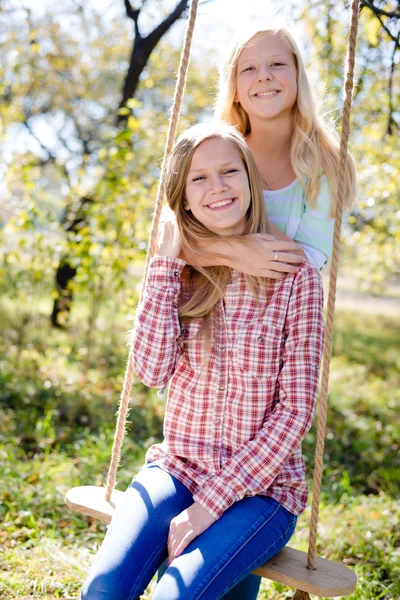 Meisjes omarmen samen in herfst park — Stockfoto