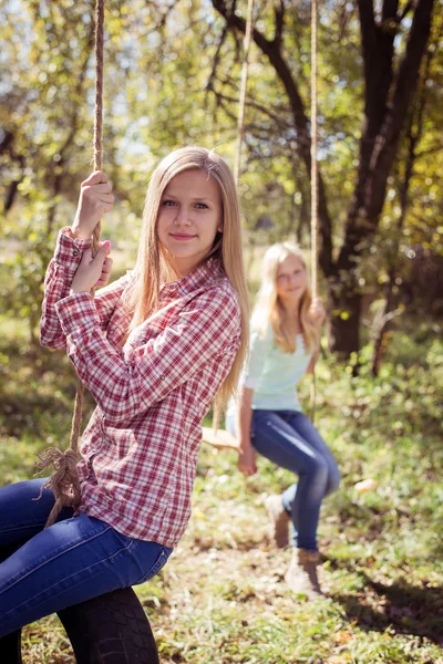 Dospívající dívky, které seděly na výkyvy v parku — Stock fotografie