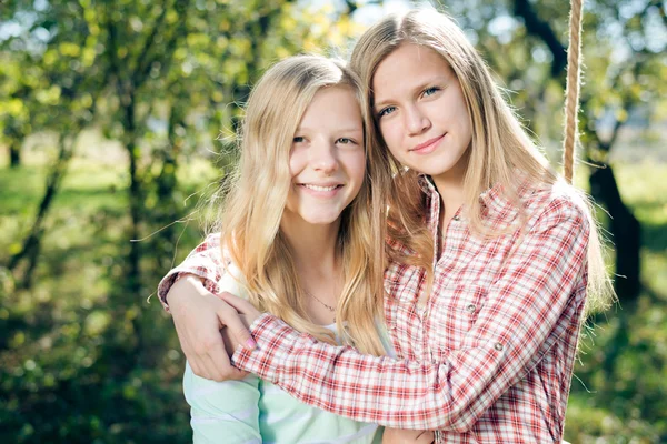 Girls embracing together in autumn park — Stock Photo, Image