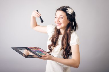 Makyaj yapan genç bir kadın.