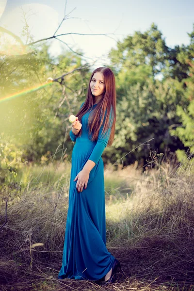 Menina em um vestido azul comendo uma maçã — Fotografia de Stock