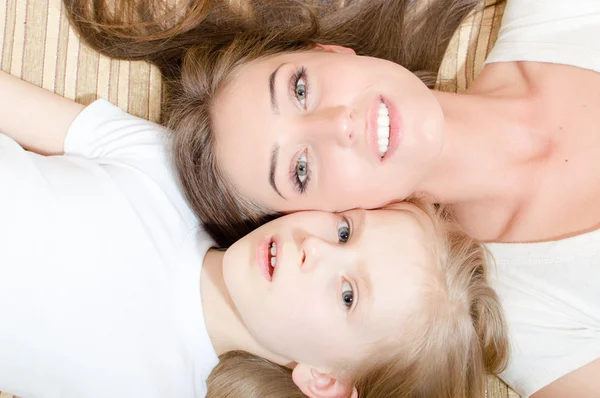 Mother and daughter lying on sofa