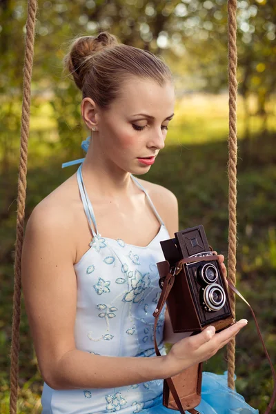 Woman in prom dress sitting on swing — Stock Photo, Image