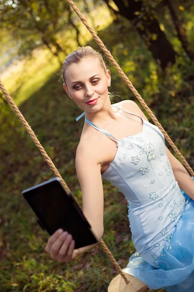 Frau sitzt auf Schaukel und macht Selfie — Stockfoto