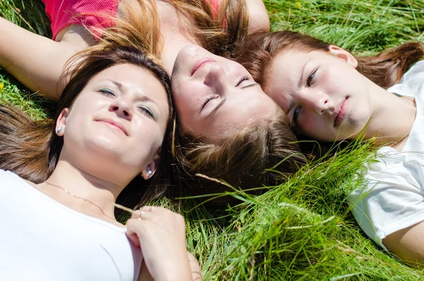 Τρία κορίτσια εφήβων ξαπλωμένος στο χόρτο — Φωτογραφία Αρχείου