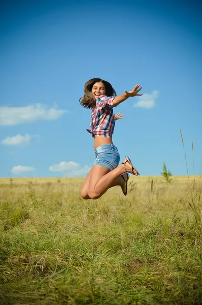 Девочка-подросток, прыгающая на летнем поле — стоковое фото