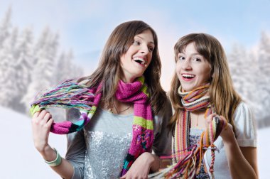 girls in knitted scarfs on winter background