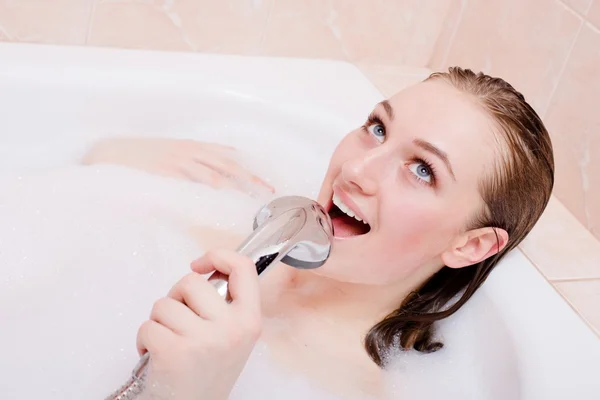 Young woman in foam bath having fun singing at shower — Stok fotoğraf