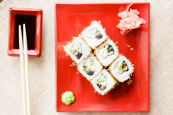 Delicious sushi with wasabi and ginger on red plate — Stock Photo, Image