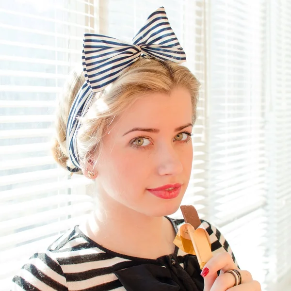 Beautiful blond young woman with red lips eating chocolate — Stock Photo, Image