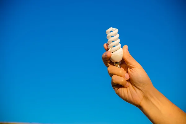 Mano con lampadina a risparmio energetico — Foto Stock