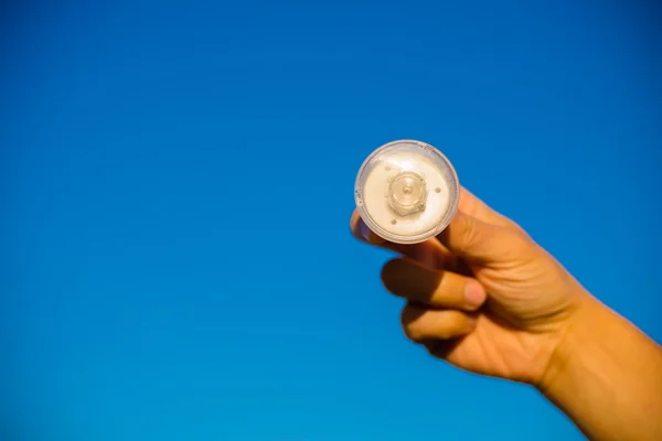 LED lamp in hand against blue sky — Stock Photo, Image