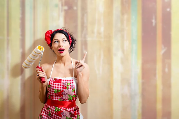 Mujer sorprendida sosteniendo rodillo de pintura — Foto de Stock