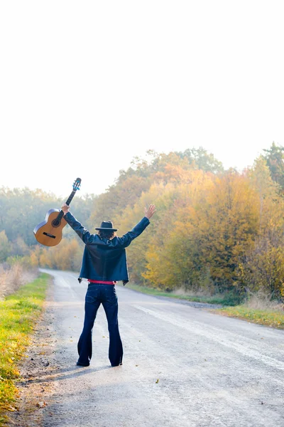 Solitario guitarrista mirando el camino vacío — Foto de Stock