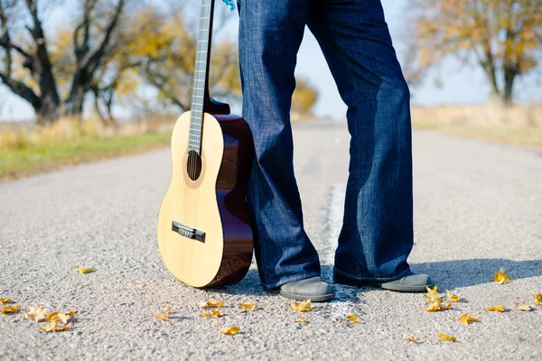 Man's legs in jeans with guitar — Stock Photo, Image