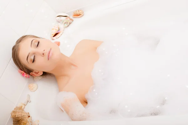 Jonge mooie vrouw in schuim bad — Stockfoto