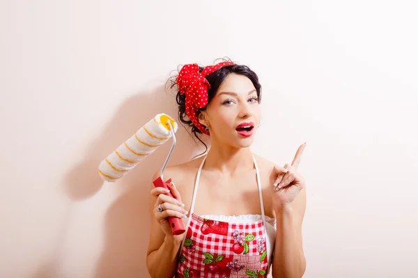 Amazed woman holding paint roller — Stockfoto